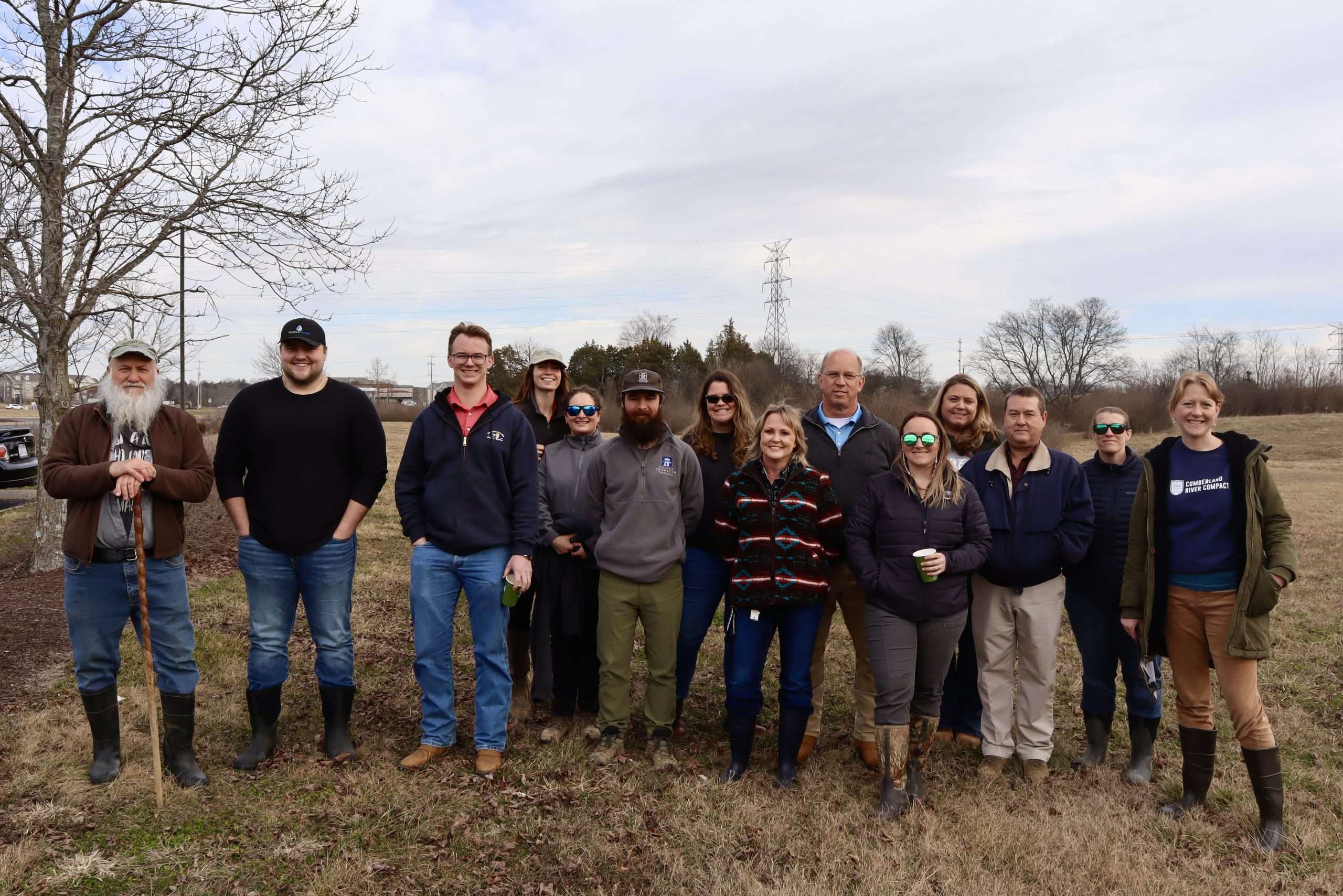 A group of thirteen individuals pose for a group photo.